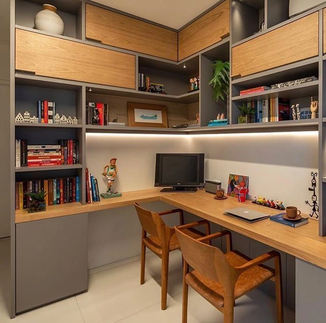 Home office planejado com bancada em L e estantes modulares