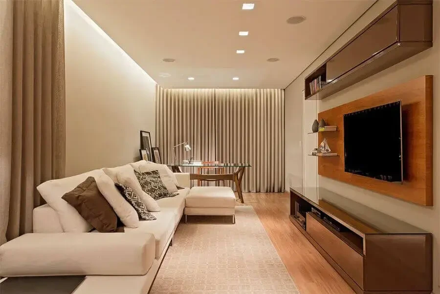 Sala de estar com painel de TV planejado e prateleiras iluminadas